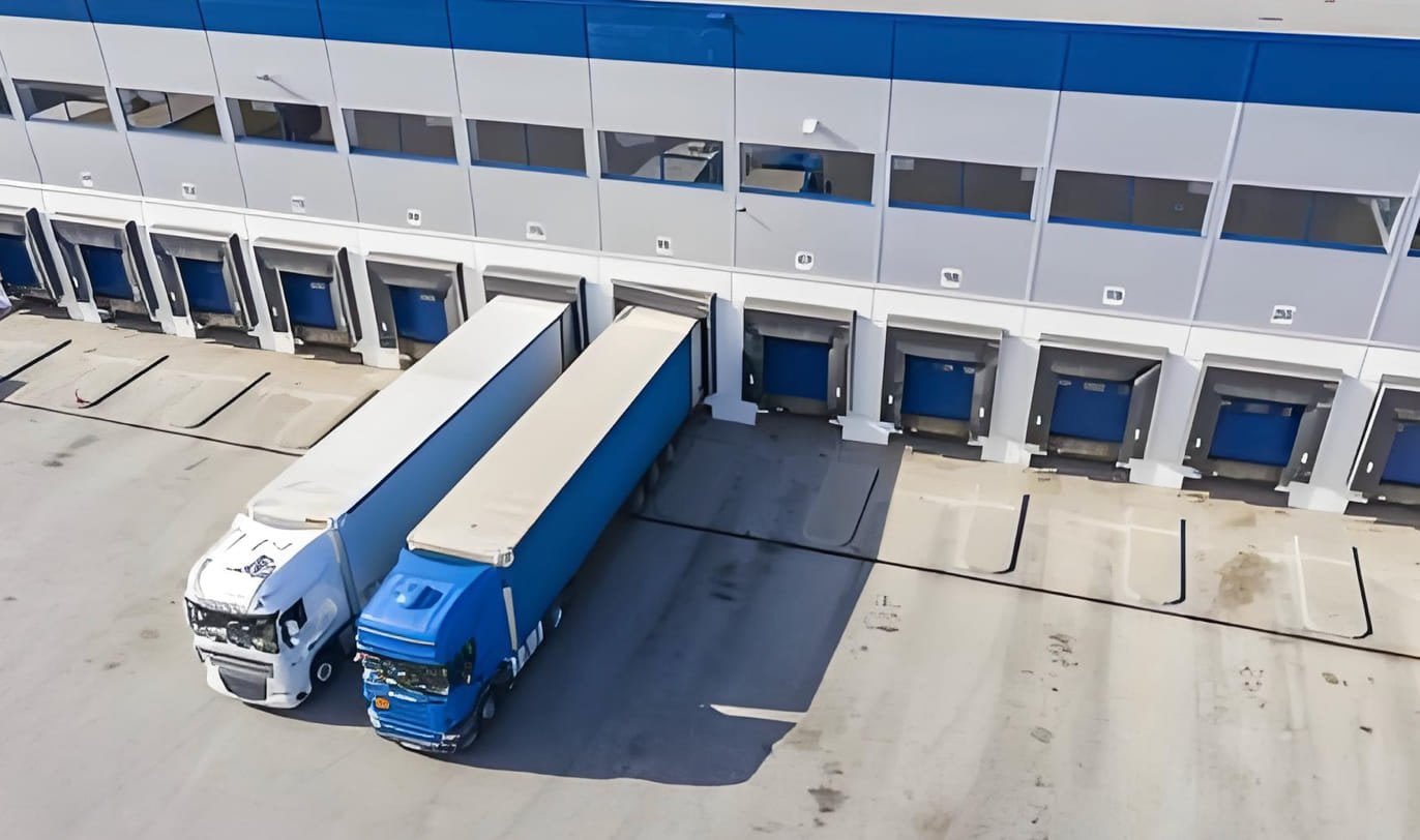 A delivery truck in front of a warehouse, symbolizing final delivery