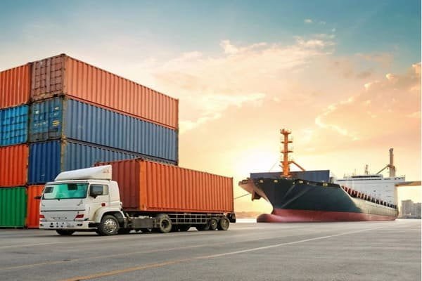 Two business people shaking hands in front of a warehouse