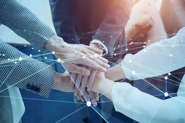 Two business people shaking hands over a desk, resolving a dispute