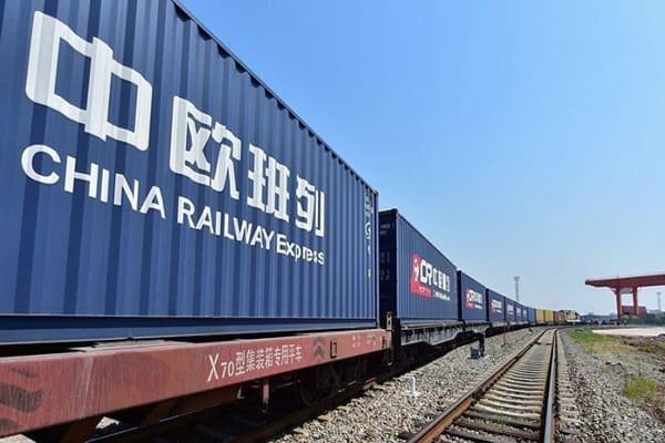 alt text: Cargo containers being loaded onto a freight train