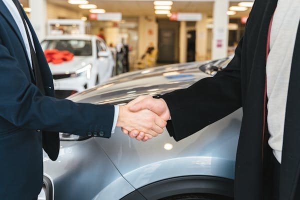 A person signing paperwork at a car dealership in China