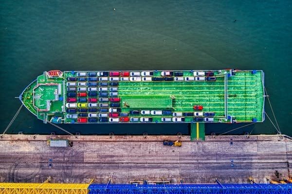 A modern Chinese EV being loaded into a shipping container