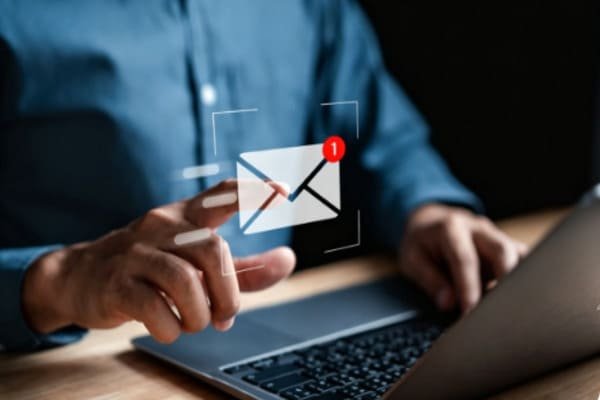 A computer screen showing a phishing email next to a real one