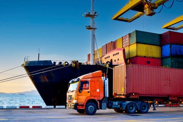 A car being loaded into a shipping container for export