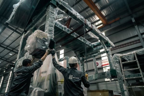 A person taking photos of a crane before it is shipped
