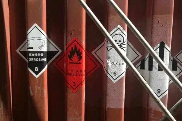 A container ship with hazardous goods placards at a port