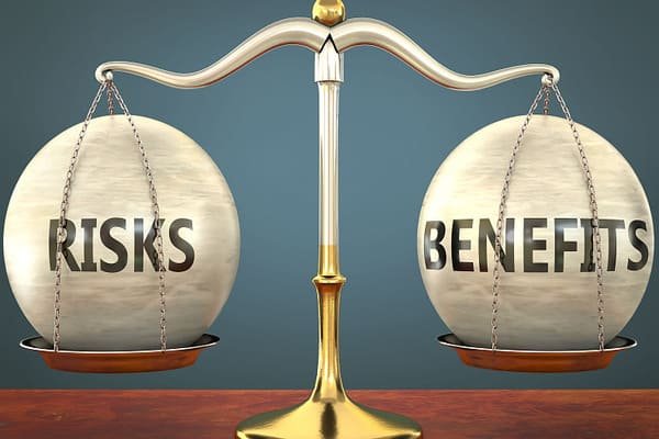 A scale balancing a dollar sign on one side and a shield on the other.