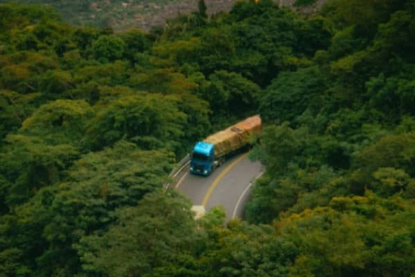 A truck carrying shipping containers on a highway between China and Vietnam