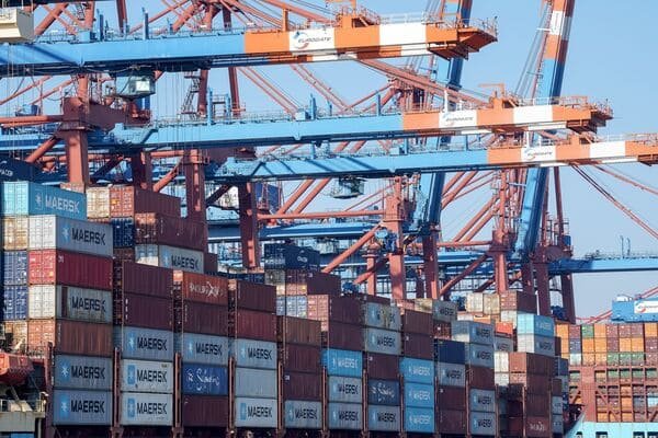 A checklist on a clipboard with shipping containers in the background.