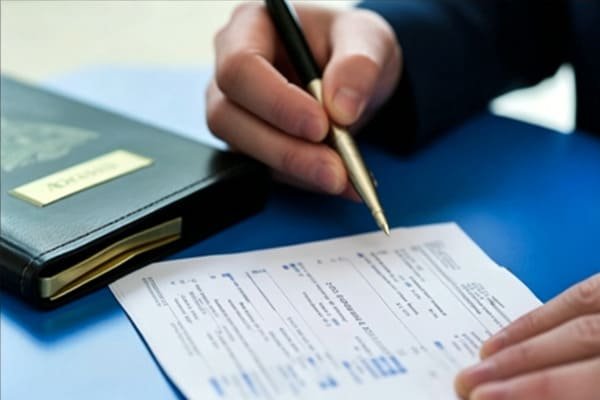 A freight forwarder inspecting cargo with a checklist
