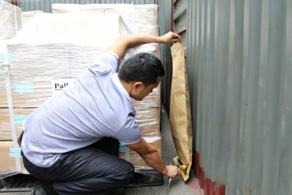 A professional freight forwarder correctly placing dunnage airbags in a container