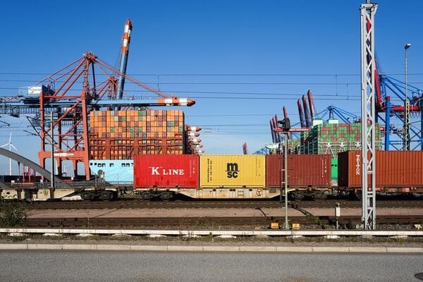 Heavy machinery being loaded onto a freight train