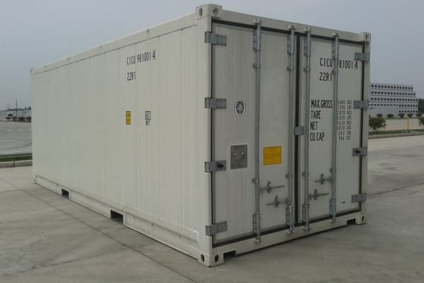 A reefer container being loaded at a busy port