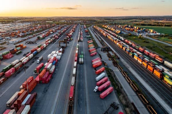 A customs officer waving a container truck through a port without stopping it