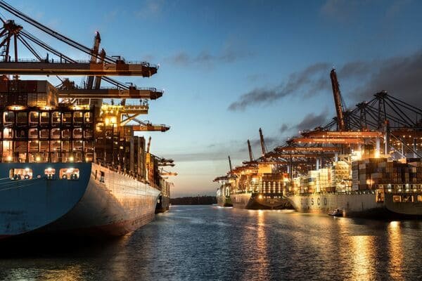 A busy container port with ships and cranes, representing shipping from China to Malaysia