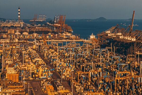 Cranes loading containers onto a ship at dusk