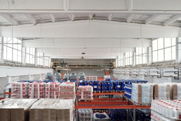 A red warning sign placed on a stack of cardboard boxes in a warehouse, indicating high-risk cargo.